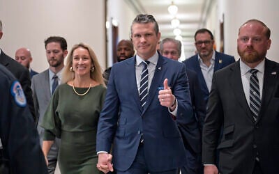 Pete Hegseth, US President-elect Donald Trump's nominee to be defense secretary, gives a thumbs-up as he walks with his wife Jennifer Rauchet, at the Capitol in Washington, December 9, 2024. (J. Scott Applewhite/AP)
