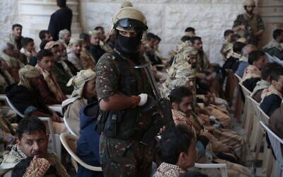 A Houthi soldier escorts released prisoners loyal to the Yemeni government after their release, in Sanaa, Yemen, January 25, 2025. (AP Photo/Osamah Abdulrahman)