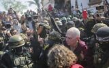 Gadi Moses, 80, center right, who has been held hostage by Hamas in Gaza since October 7, 2023, is escorted by Hamas and Islamic Jihad fighters as he is handed over to the Red Cross in Khan Younis, southern Gaza Strip, January 30, 2025. (AP Photo/Jehad Alshrafi)
