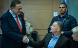 Defense Minister Israel Katz (left) shakes hands with Foreign Affairs and Defense Committee Chairman Yuli Edelstein during a committee discussion on the IDF conscription law in the Knesset on January 21, 2025. (Yonatan Sindel/Flash90)