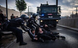 Police drag away ultra-Orthodox protesters who sat on the road during a demonstration against Haredi enlistment, outside a conference honoring ultra-Orthodox soldiers in Jerusalem, January 28, 2025. (Chaim Goldberg/Flash90)