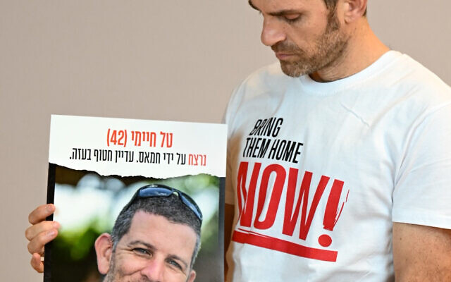 In a photo released on January 16, 2025, Udi Goren poses with a poster of his cousin Tal Chaimi, who was killed and his body taken captive to Gaza on October 7, 2023. (Hostages Forum)