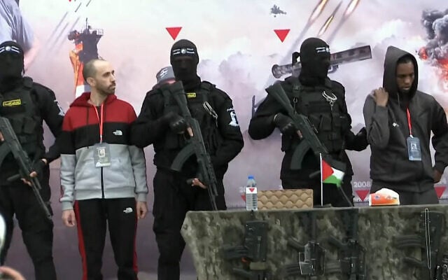 Hostages Tal Shoham (2nd L) and Avera Mengistu (R), surrounded by armed fighters, stand on a stage in Rafah as they are released by the Hamas terror group in Rafah on February 22, 2025 (Screen grab/YouTube)