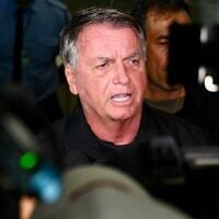 Former Brazilian President Jair Bolsonaro speaks to members of the media after accompanying his wife, Michelle Bolsonaro, to board a plane bound for the US to represent him in President-elect Donald Trump's inauguration after a Brazilian judge denied his request to travel at Brasilia airport on January 18, 2025 (EVARISTO SA / AFP)