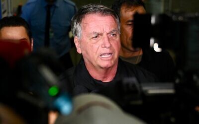 Former Brazilian President Jair Bolsonaro speaks to members of the media after accompanying his wife, Michelle Bolsonaro, to board a plane bound for the US to represent him in President-elect Donald Trump's inauguration after a Brazilian judge denied his request to travel at Brasilia airport on January 18, 2025 (EVARISTO SA / AFP)