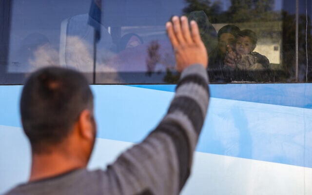 A man waves at his wife and child sitting in a bus as patients from al-Shifa hospital in Gaza City wait to be evacuated for treatment through the Rafah crossing on February 1, 2025.  (Photo by BASHAR TALEB / AFP)