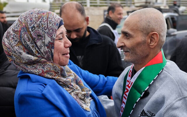 A former Palestinian prisoner released by Israel is greeted by a relative upon his arrival in Ramallah on buses of the International Committee of the Red Cross (ICRC) on February 1, 2025.  (Photo by AHMAD GHARABLI / AFP)