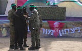Hamas gunmen stand in front of a stage before they hand over three Israeli hostages to a Red Cross team in Deir el-Balah, central Gaza, on February 8, 2025. (BASHAR TALEB / AFP)
