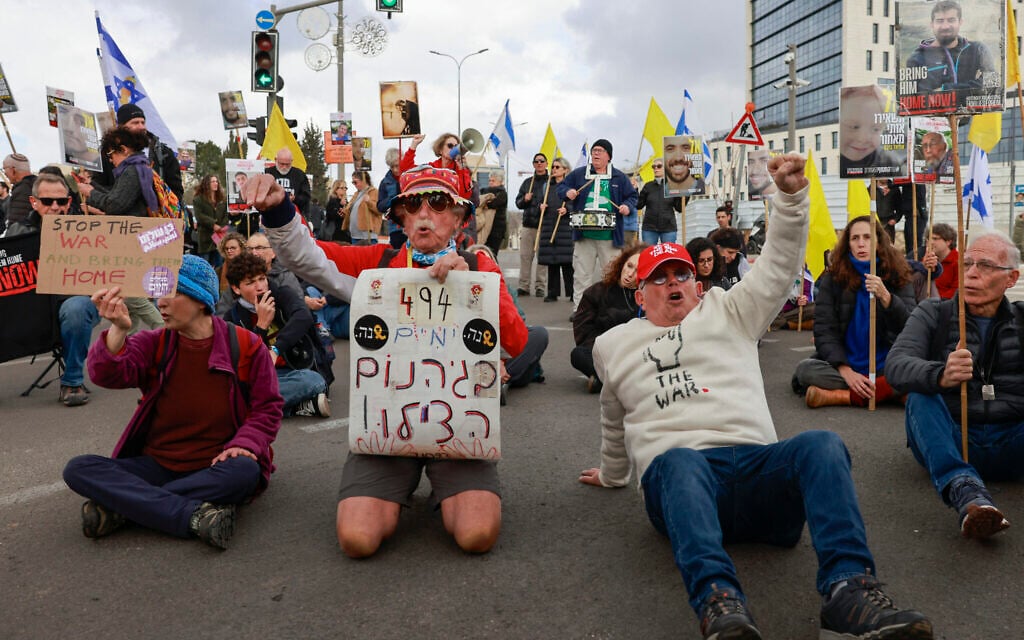 Supporters of Israelis held hostage in the Gaza Strip since October 2023 lift placards and flags during a rally calling to complete the exchange deal with Hamas in front of the prime minister's office in Jerusalem on February 11, 2025. (Photo by Menahem KAHANA / AFP)