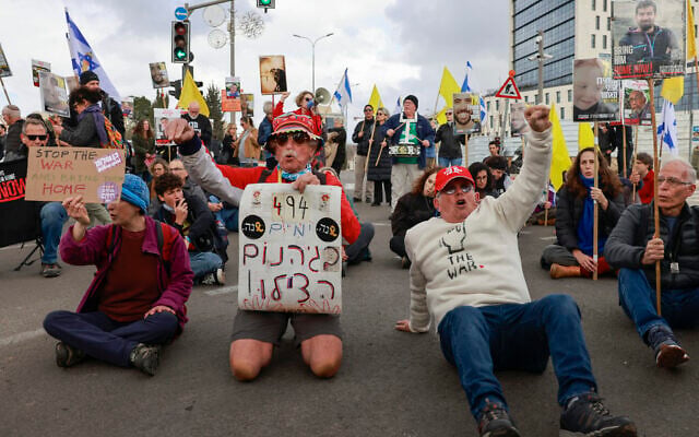 Supporters of Israelis held hostage in the Gaza Strip since October 2023 lift placards and flags during a rally calling to complete the exchange deal with Hamas in front of the prime minister's office in Jerusalem on February 11, 2025. (Photo by Menahem KAHANA / AFP)
