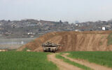 A picture taken from the Israeli side of the border with the Gaza Strip shows an Israeli army tank stationed on a hill overlooking northern Gaza on February 12, 2025. (Menahem KAHANA / AFP)