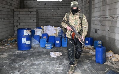 A member of the Syrian security forces searches a defunct drug factory inside an abandoned building near the village of Hawik in the countryside of Qusair, Syria on February 12, 2025. (Louai Beshara/AFP)