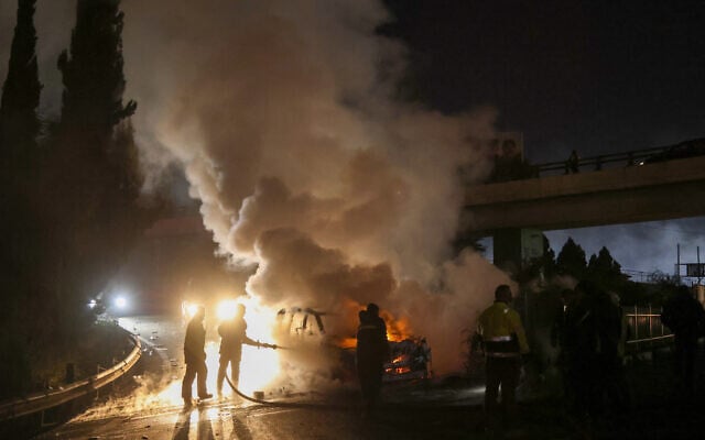 Firefighters extinguish a burning UNIFIL vehicle, set ablaze by protesters, on the road leading to Beirut's international airport on February 14, 2025 (IBRAHIM AMRO / AFP)