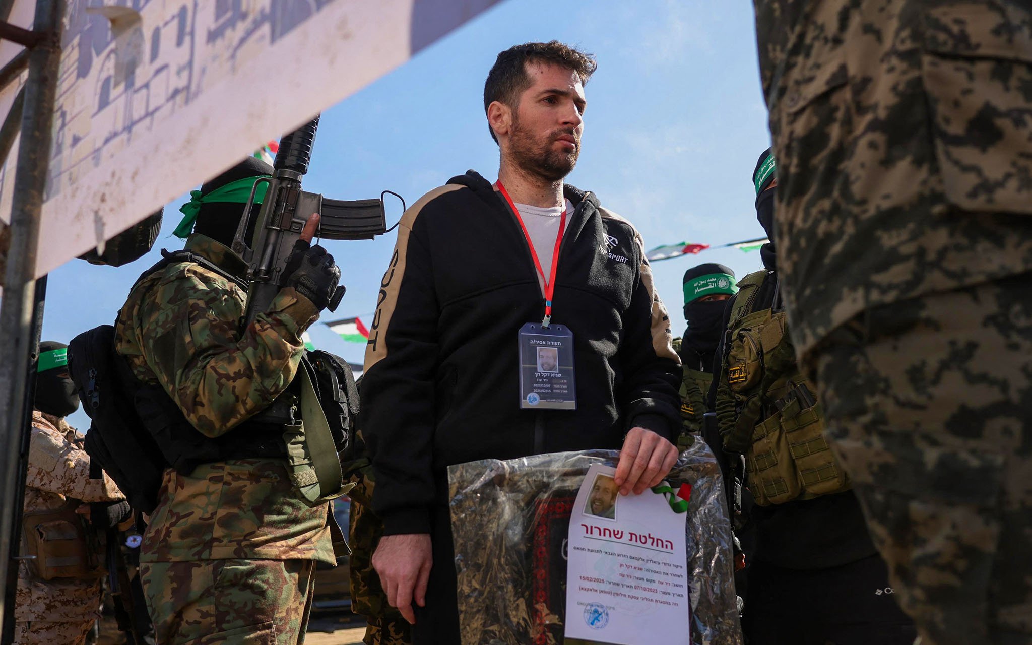 Hamas gunmen parade hostage Sagui Dekel-Chen on a stage before handing him over to a Red Cross team in Khan Younis, southern Gaza Strip, on February 15, 2025 (Bashar TALEB / AFP)