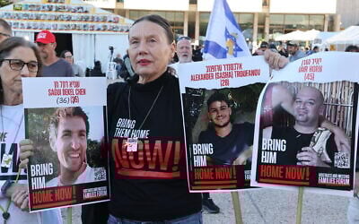 A woman holds pictures of three released Israeli hostages in Tel Aviv on February 15, 2025 in the city's Hostages Square. (Jack GUEZ / AFP)