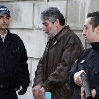 French policemen escort Georges Ibrahim Abdallah (C), a Lebanese terrorist sentenced to life in prison for the murder of two diplomats, one American and the other Israeli, as Abdallah leaves Pau's Courthouse, southwestern France, on February 18, 2010. (Jean-Louis Duzert / AFP)