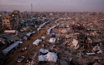 Palestinians walk past tents lining the streets amid the rubble of destroyed buildings in Jabalia, in the northern Gaza Strip, February 18, 2025. (Omar Al-Qattaa / AFP)