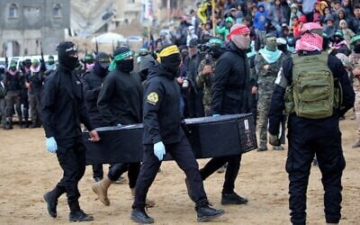 Palestinian terrorists carry to the Red Cross one of four coffins said to hold a body of a slain Israeli hostage, in the southern Gaza Strip's Khan Younis, February 20, 2025. (Eyad Baba / AFP)