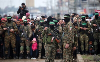 Gazans, including young children, and Hamas gunmen gather shortly before the release of three Israeli hostages in Nuseirat in the central Gaza Strip on February 22, 2025. (Eyad Baba/AFP)