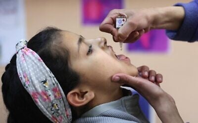 A Palestinian student receives a polio vaccine on the first day of classes at a school in Gaza City on February 23, 2025, as part of a polio vaccination campaign. (Omar Al-Qattaa / AFP)