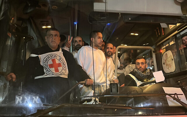 Palestinian prisoners, released by Israel, gesture as they arrive on a bus at the European Hospital in Khan Yunis in the southern Gaza Strip early on February 27, 2025. Hamas handed over the coffins of four hostages early on February 27, Israeli authorities confirmed, followed soon after by the return of hundreds of freed Palestinian prisoners to the West Bank and Gaza. In the West Bank and Gaza, AFP journalists saw hundreds of Palestinian prisoners freed by Israel arrive on buses accompanied by Red Cross vehicles. More than 600 were due to be released in the latest exchange, while Al Jazeera reported nearly 100 would be deported to Egypt. (Photo by AFP)