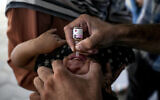 A health worker administers a polio vaccine to a child at a hospital in Deir al-Balah, central Gaza Strip, September 1, 2024. (AP Photo/Abdel Kareem Hana)