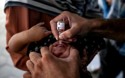 A health worker administers a polio vaccine to a child at a hospital in Deir al-Balah, central Gaza Strip, September 1, 2024. (AP Photo/Abdel Kareem Hana)