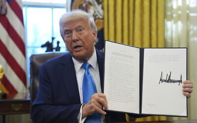 US President Donald Trump holds an executive order regarding withdrawing from the United Nations Human Rights Council in the Oval Office of the White House, February 4, 2025, in Washington. (AP Photo/Evan Vucci)