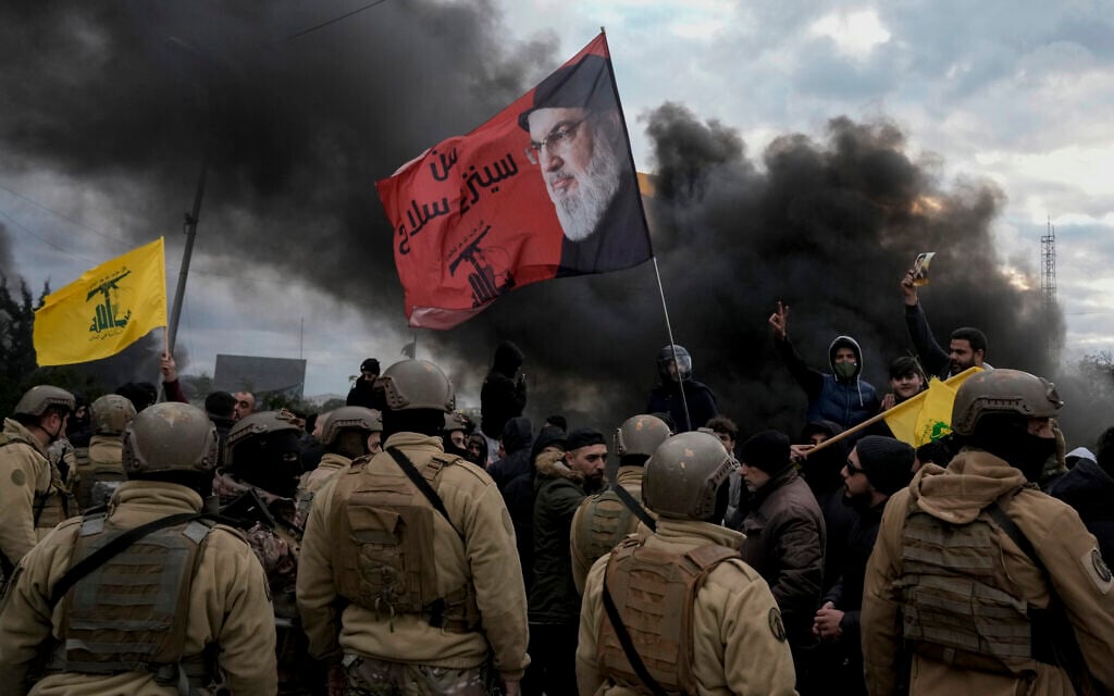 Hezbollah supporters hold the terror group's flags with a picture of slain leader Hassan Nasrallah as they block a road link to the international airport during a protest against statements made by US deputy special envoy for Middle East peace Morgan Ortagus after she met with the country's president, in Beirut, Lebanon, February 7, 2025. (AP Photo/Bilal Hussein)