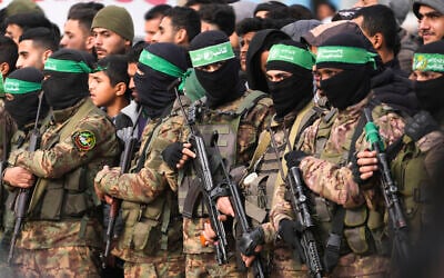 Illustrative: Hamas gunmen stand in formation ahead of a hostage release in Deir al-Balah, in the central Gaza Strip, February 8, 2025. (AP Photo/Abdel Kareem Hana)