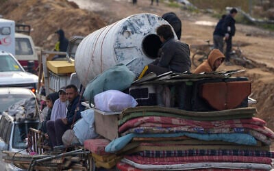 Displaced Palestinians wait at a security checkpoint in the Netzarim corridor while traveling from central Gaza to their homes in the northern Gaza Strip, February 11, 2025. (AP Photo/Abdel Kareem Hana)