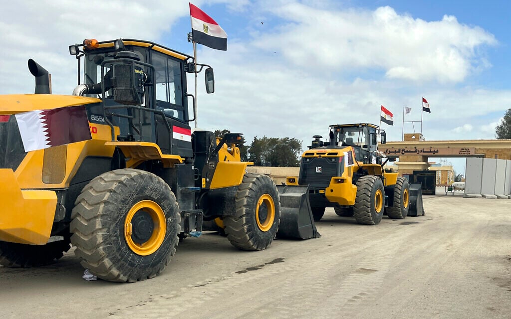 Bulldozers with Egyptian and Qatar flags wait to enter Gaza at the Rafah border crossing between Egypt and the Gaza Strip, February 13, 2025. (AP Photo/Mohamed Arafat)