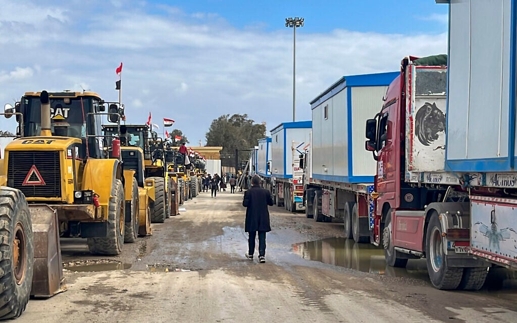Bulldozers and trucks carrying caravans wait to enter Gaza at the Rafah border crossing between Egypt and the Gaza Strip, Thursday, Feb. 13, 2025. (AP Photo/Mohamed Arafat)