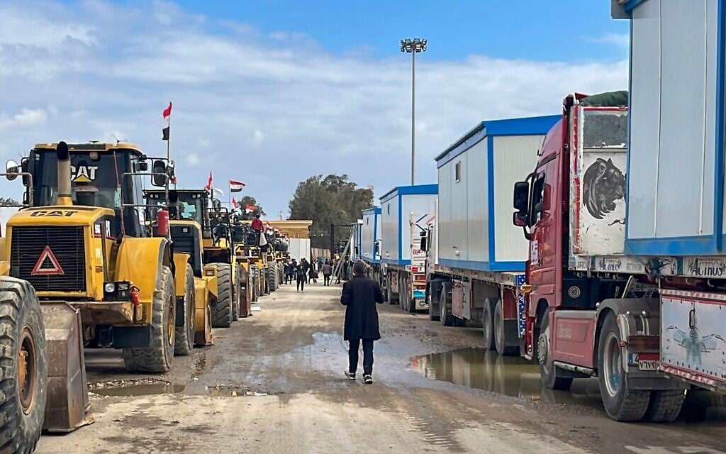 Bulldozers and trucks carrying mobile homes wait to enter Gaza at the Rafah border crossing between Egypt and the Gaza Strip, February 13, 2025. (AP Photo/Mohamed Arafat)