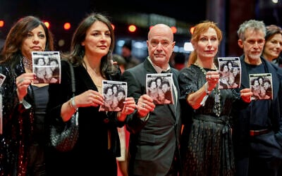 German actors and actresses hold photos of Israeli hostage David Cunio upon arrival at the opening of the International Film Festival, Berlinale, in Berlin, February 13, 2025. (AP Photo/Markus Schreiber)