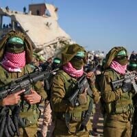 Illustrative: Hamas gunmen, wearing captured IDF uniforms and brandishing Israeli weapons, stand in formation in Khan Younis, in the southern Gaza Strip, February 15, 2025. (AP Photo/Abdel Kareem Hana)