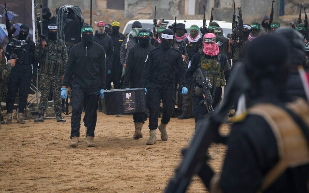 Hamas terrorists carry the coffin apparently of a slain Israeli hostage as they hand over four such coffins to the Red Cross in Khan Younis, Gaza, February 20, 2025. (AP/Abdel Kareem Hana)