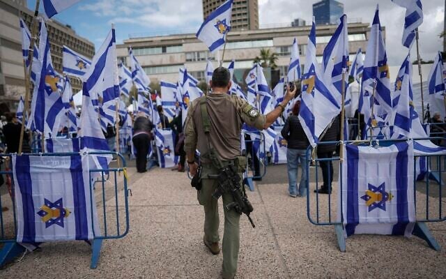 An Israeli soldier holds his cellphone as he walks into "Hostages Square" in Tel Aviv, Thursday, Feb. 20, 2025, as Palestinian terror groups hand over the bodies of four slain Israeli hostages, including a mother and her two children, to the Red Cross in Gaza. (AP Photo/Oded Balilty)