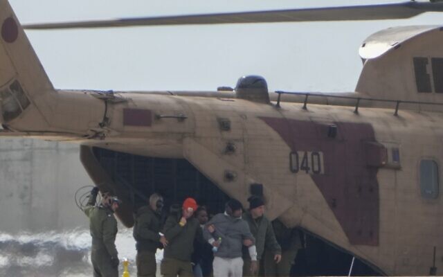 Freed Israeli hostage Avera Mengistu (wearing grey) exits a military helicopter as he arrives at the Ichilov hospital after being released from Gaza by Hamas, in Tel Aviv, Feb. 22, 2025. (AP Photo/Ariel Schalit)