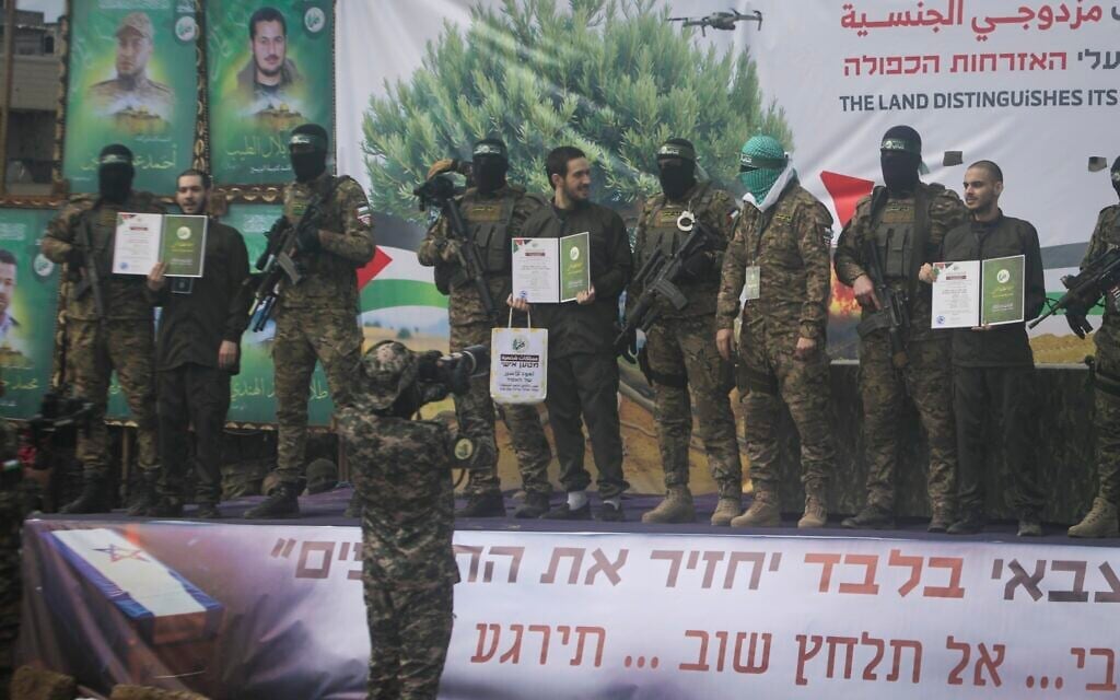 Israeli hostages, from left to right, Eliya Cohen, Omer Shem and Omer Wenkert, are told to show Hamas issued certificates by before being handed over to the Red Cross in Nuseirat, central Gaza Strip, Saturday, February 22, 2025. (AP/Jehad Alshrafi)