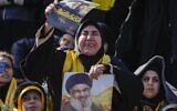 Mourners react as a trailer carrying the coffins containing the bodies of Hezbollah's former leader Hassan Nasrallah and his cousin and successor Hashem Safieddine drives through the crowd at the beginning of a funeral procession in the Sports City Stadium in Beirut, Lebanon, February 23, 2025. (AP Photo/Hussein Malla)
