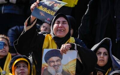 Mourners react as a trailer carrying the coffins containing the bodies of Hezbollah's former leader Hassan Nasrallah and his cousin and successor Hashem Safieddine drives through the crowd at the beginning of a funeral procession in the Sports City Stadium in Beirut, Lebanon, February 23, 2025. (AP Photo/Hussein Malla)