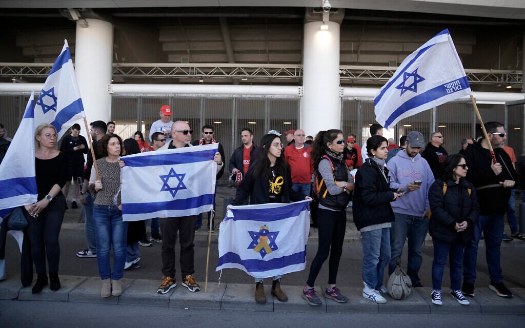 Friends, family and soccer fans at a public memorial ceremony for slain hostage Tsachi Idan, watch a van carrying his coffin outside of Bloomfield Stadium in Tel Aviv, Feb. 28, 2025. (AP/Leo Correa)