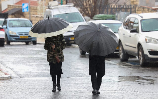 People walk in the rain in the northern Israeli city of Safed, February 20, 2025. (David Cohen/Flash90) People walk in the rain in the northern Israeli city of Safed, February 20, 2025. (David Cohen/Flash90)