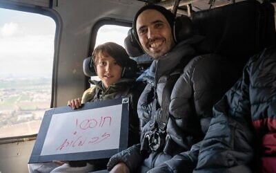 Freed hostage Tal Shoham and his son Naveh on a helicopter en route to a hospital after his release, February 22, 2025 (IDF)