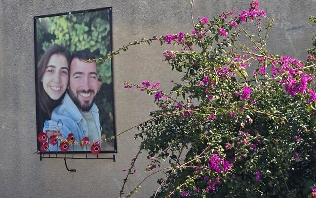 A poster memorializing Nirel Zini and Niv Raviv hangs outside the house where they lived in a neighborhood for young families at Kibbutz Kfar Aza, February 2025. (Bernard Dichek)