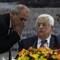 Director of Palestinian General Intelligence in the West Bank Majid Faraj (L) whispers to President Palestinian president Mahmud Abbas during a meeting where he requested to join 15 United Nations agencies, abandoning pledges to refrain from doing so during nine months of talks that were to end April 29, at his headquarters in the West Bank city of Ramallah on April 1, 2014. AFP PHOTO / ABBAS MOMANI (Photo by ABBAS MOMANI / AFP)