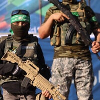 Illustrative: A Palestinian boy carries a toy gun while standing with members of Al-Qassam Brigades, the armed wing of the Hamas movement, during a rally in Gaza City on May 24, 2021. (AFP / Emmanuel DUNAND)