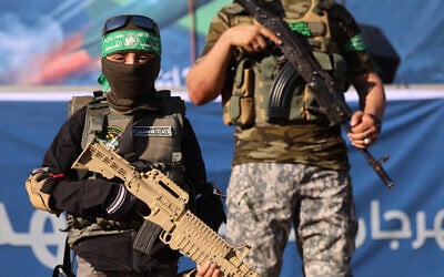 A Palestinian boy carries a toy gun while standing with members of Al-Qassam Brigades, the armed wing of the Hamas movement, during a rally in Gaza City on May 24, 2021. (AFP / Emmanuel DUNAND)