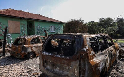 An Israeli soldier walks pas charred cars in Moshav Netiv HaAsara in southern Israel near the border with the Gaza Strip  on November 17, 2023, in the aftermath of Hamas's October 7 terror onslaught (RONALDO SCHEMIDT / AFP)